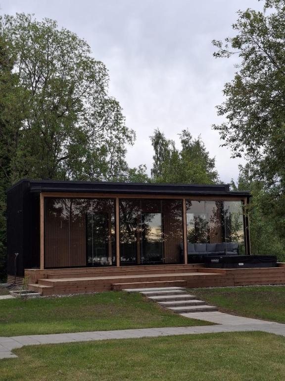a glass house with a black roof at Cottage in Raahe in Raahe