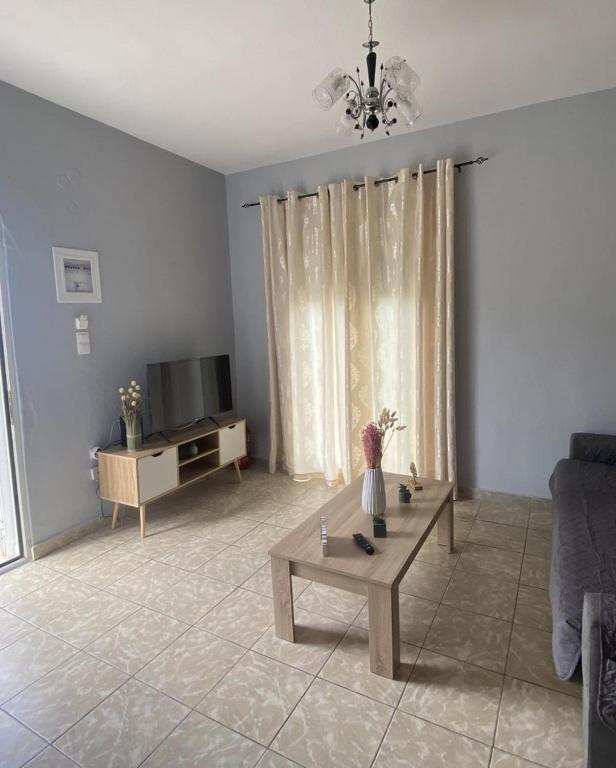 a living room with a couch and a tv at Thassos Home in Skala Kallirachis