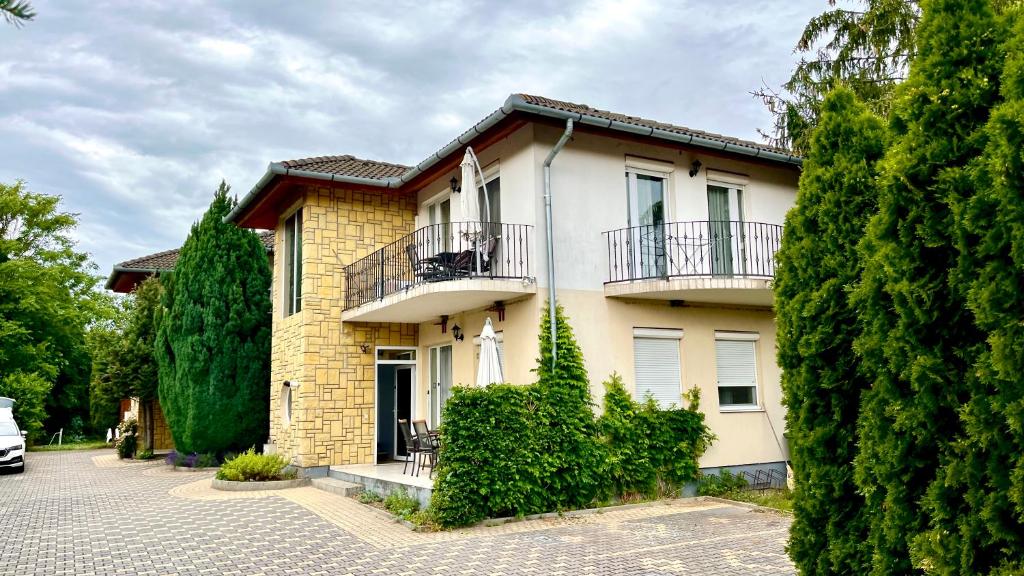 a house with a balcony on the side of it at Balatonlelle Apartmanház in Balatonlelle