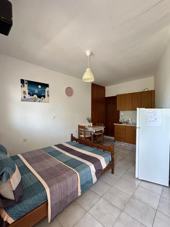a bedroom with a bed and a refrigerator at SDROSOS Apartment in Kos
