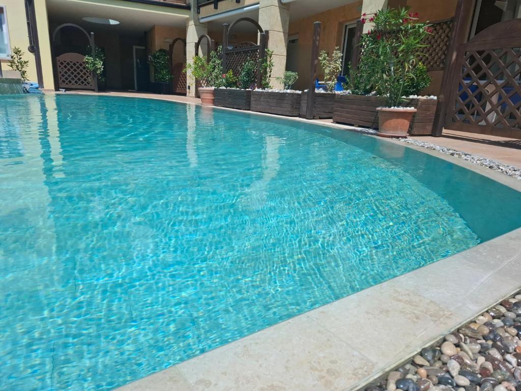 a large swimming pool with blue water at Villa Josefine Lake Front beach and Pool in Brenzone sul Garda