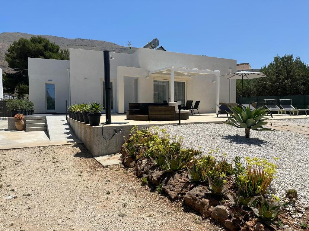a house with a patio with plants in the yard at Villa Tosto in Castelluzzo
