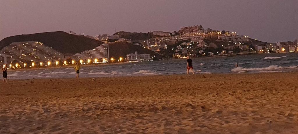 a group of people standing on a beach at night at Vistas al castillo in Cullera