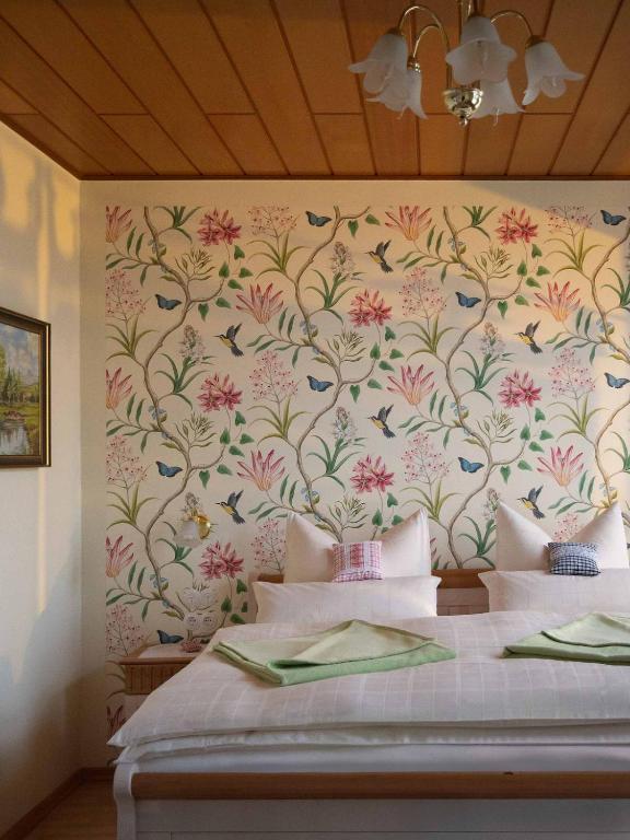 a bedroom with a bed with a floral wallpaper at Die Gute Stube in Dobritz