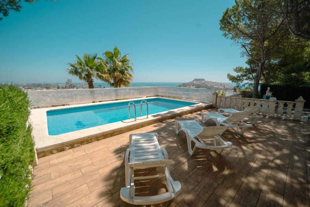 a swimming pool with some chairs and a table at Primestay - Chalet Panamá - Piscina y Vistas al Castillo in Peniscola