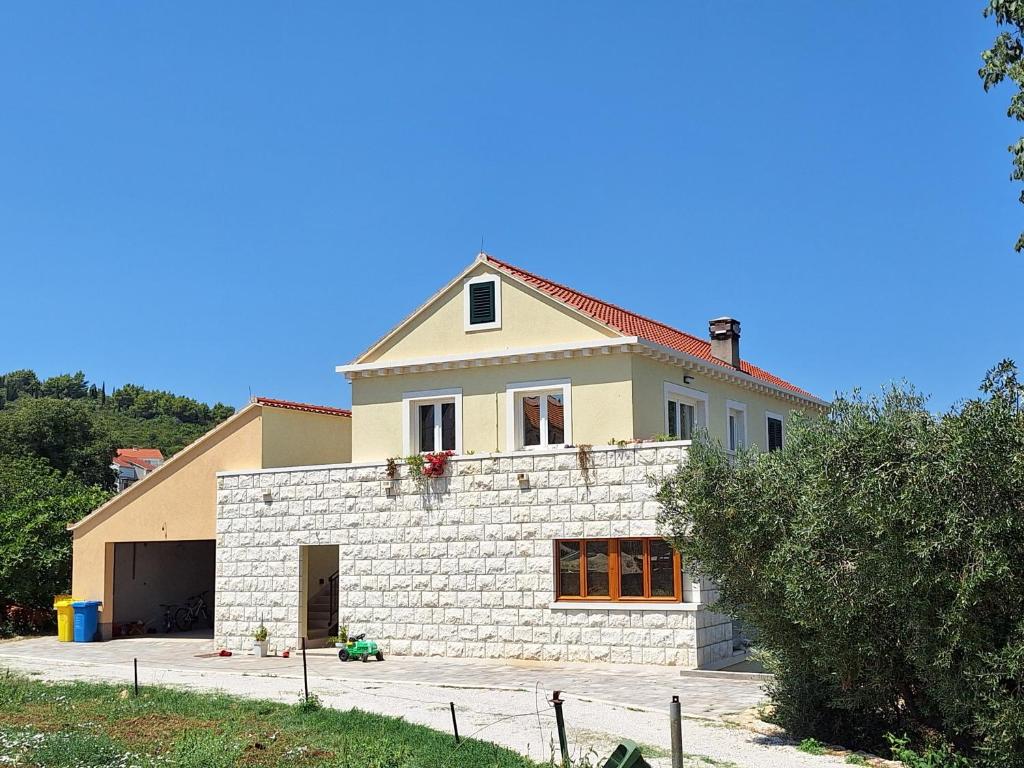 a house with a stone wall in front of it at Blue Velvet apartment in Lumbarda