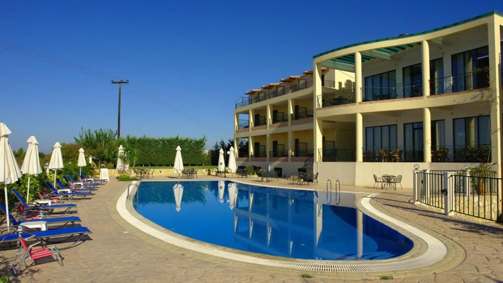 a hotel with a swimming pool in front of a building at Hotel Alkionis in Zakharo