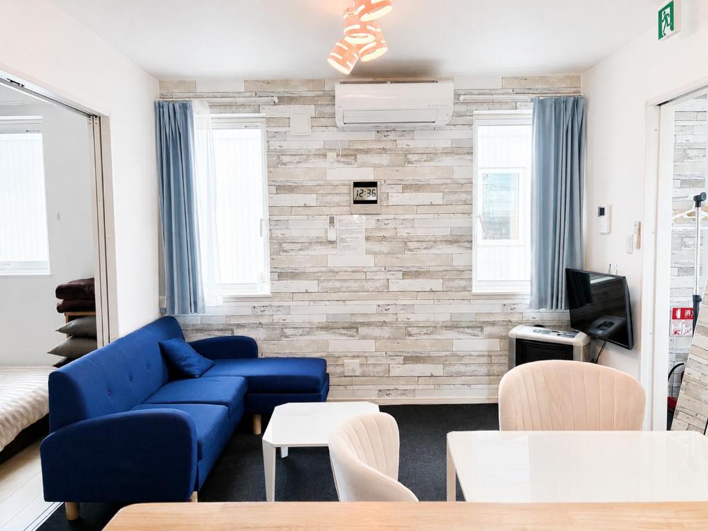 a living room with a blue couch and a brick wall at 優富良野 in Furano