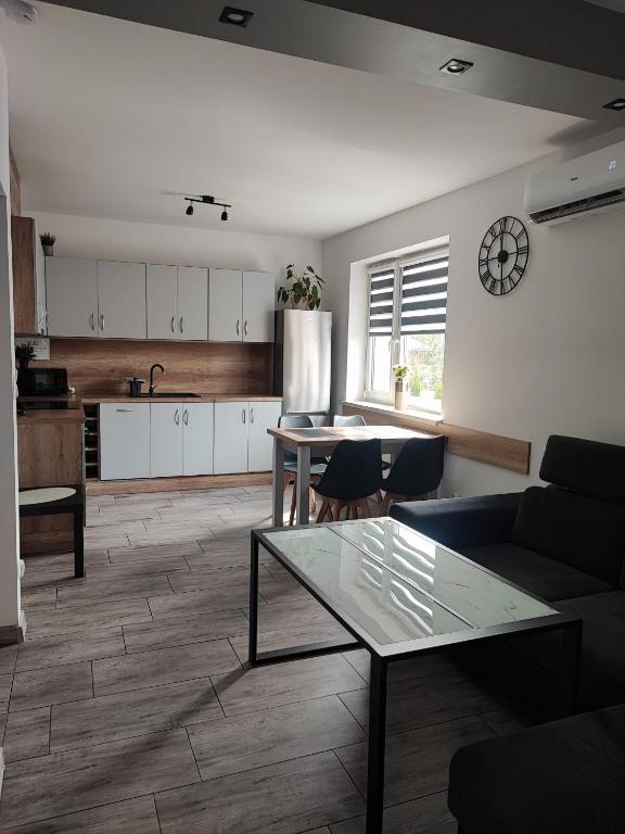 a living room with a table and a kitchen at Apartamenty NOVA - BLISKO ENERGYLANDII in Zator