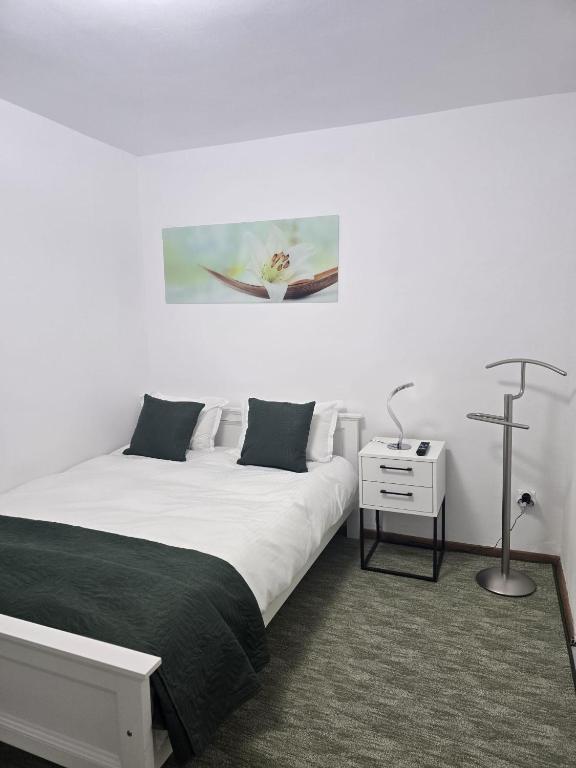 ein Schlafzimmer mit zwei Betten und einem Nachttisch mit Lampe in der Unterkunft VivaVero in Baia Mare