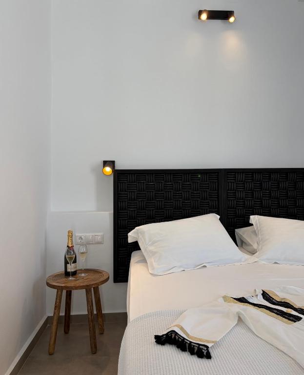 a bedroom with two beds and a table with a bottle of wine at Blue Paradise Apartments in Naxos Chora