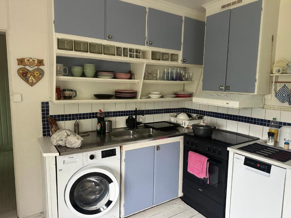 a kitchen with a sink and a washing machine at Nordic Villa Undrom in Undrom