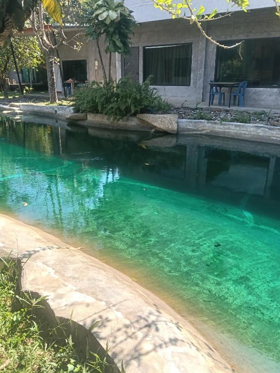 a swimming pool with blue water in front of a house at บ้านนกฮูกรีสอร์ท in Ban Chamun (2)