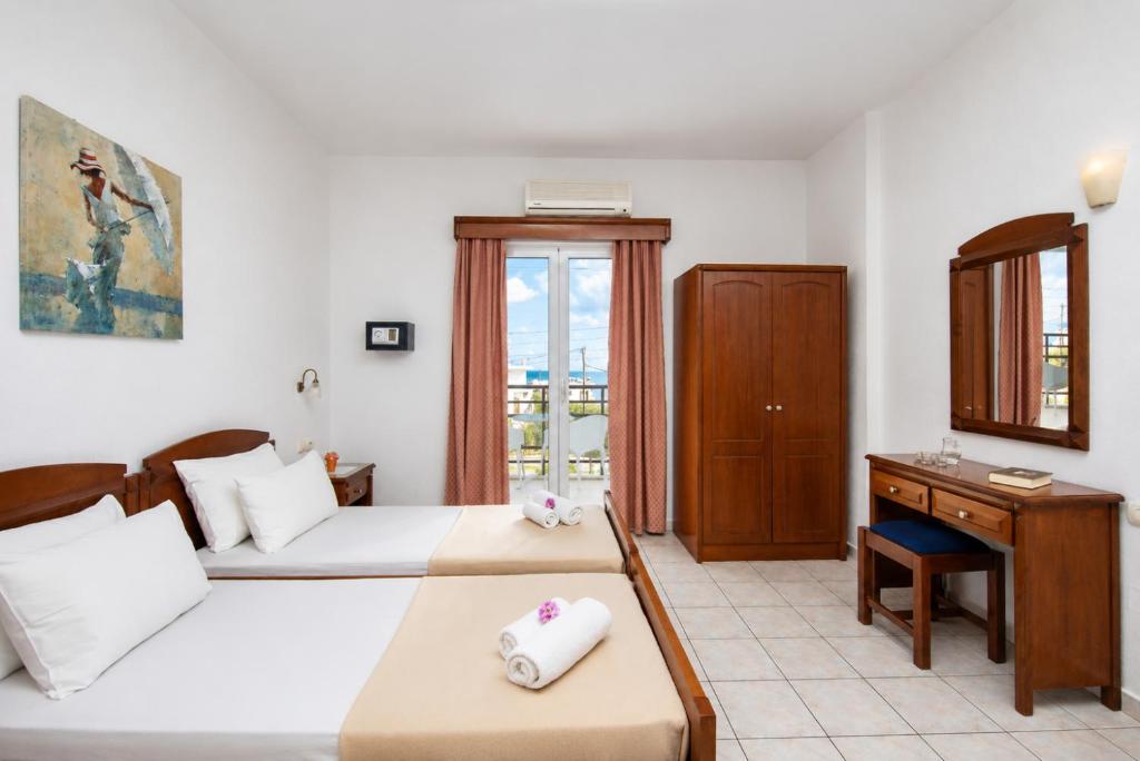 a hotel room with two beds and a desk at Astir Studios in Stalís