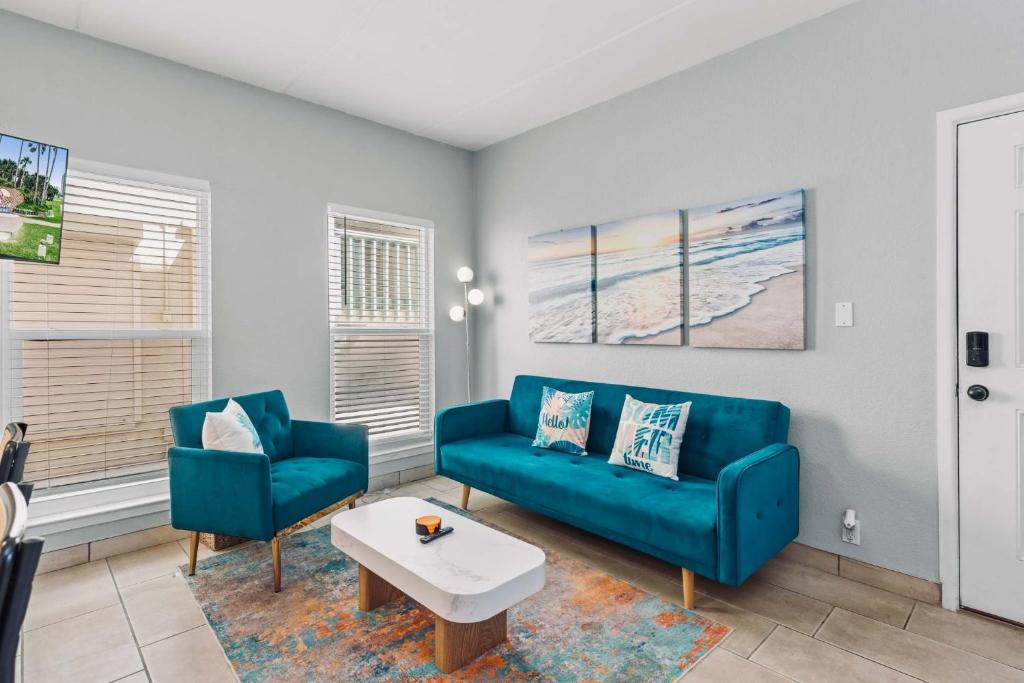 a living room with a blue couch and two chairs at SPI Beach Condo - Just a block away to Paradise in South Padre Island