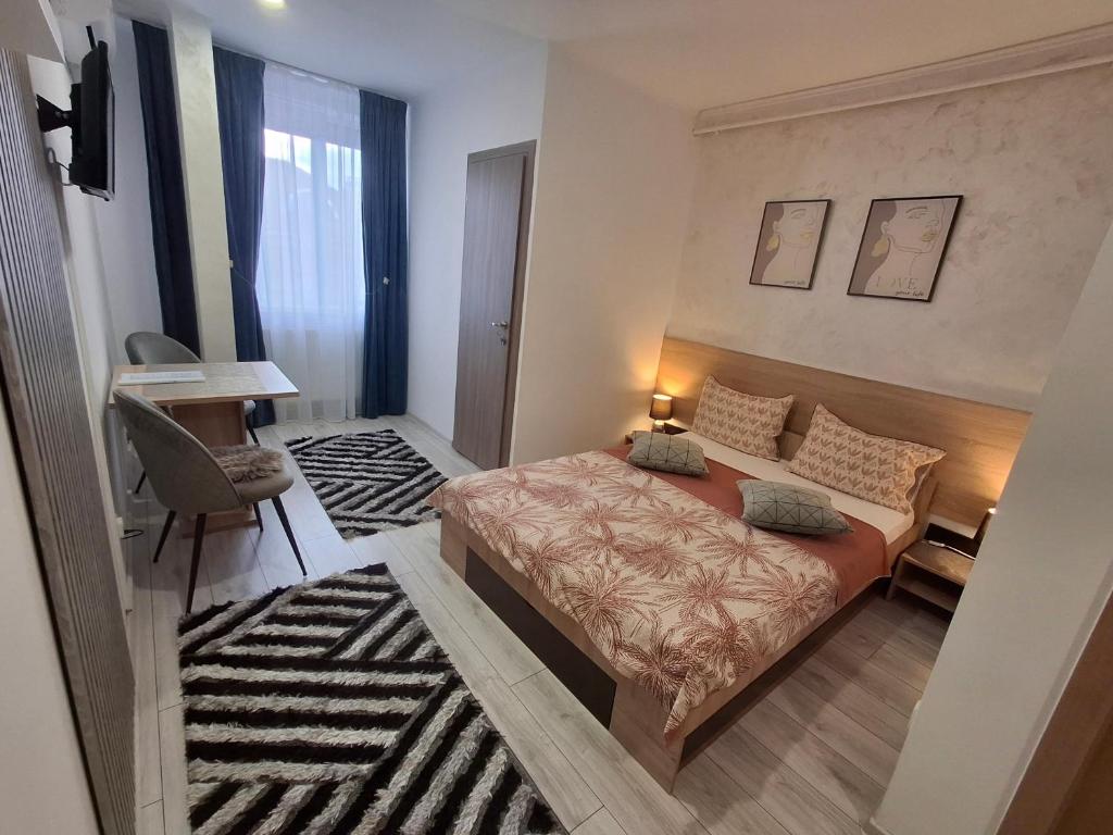 a small bedroom with a bed and a desk and a desk at Studio Elvetia in Deva