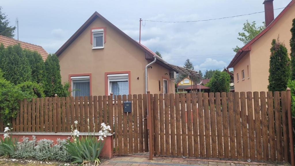 a wooden fence in front of a house at Kicsi Rigó Vendégház in Bogács