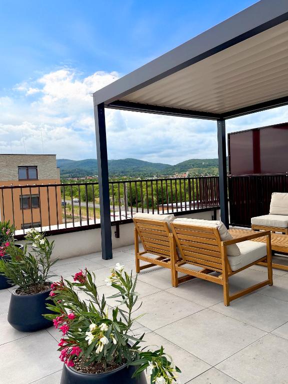 a patio with a wooden bench and a canopy at Modra Sunny Apartment in Modra