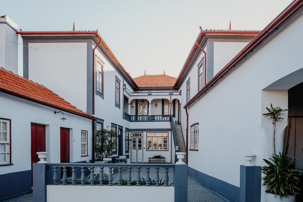 a row of white buildings with red roofs at Galricho Heritage House in Murtosa