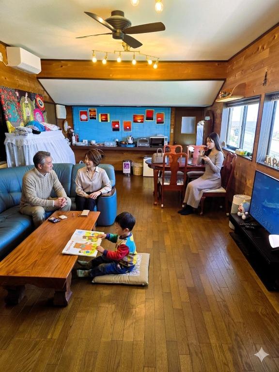 a group of people sitting in a living room at Super Henro Inn in Nahari