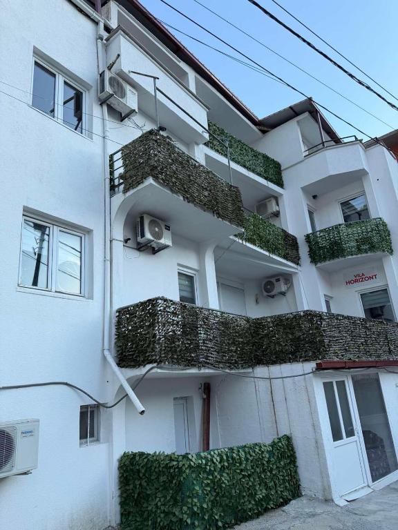 a white building with plants on the side of it at Villa Horizon Canj in Čanj