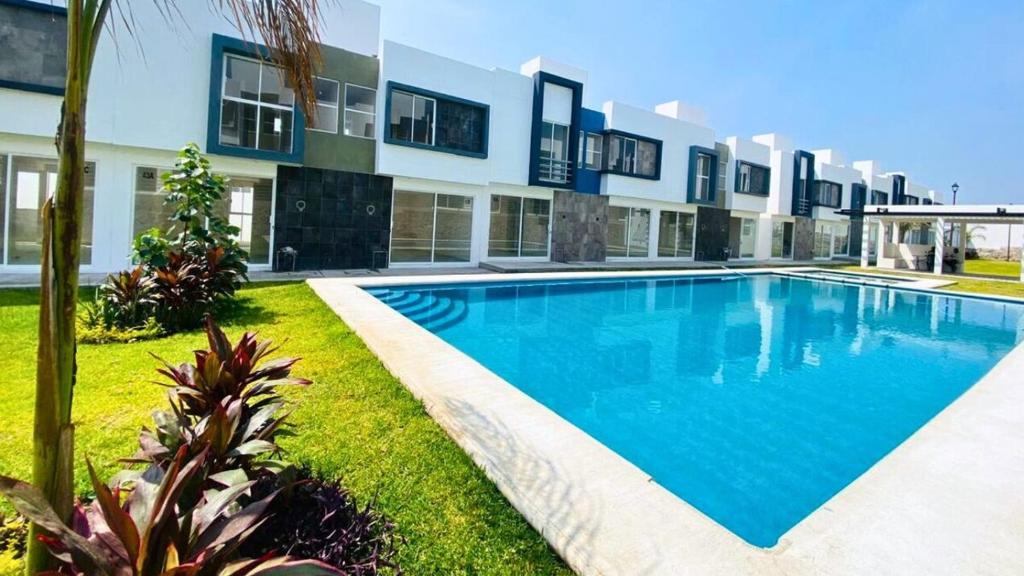 a large swimming pool in front of a building at Residencial Granate Xochitepec Morelos in Atlacholoaya