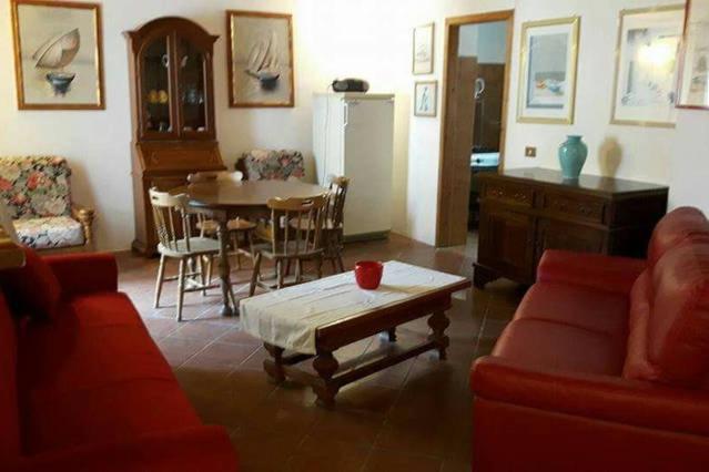 een woonkamer met een rode bank en een tafel bij Holiday Home Golfo di Orosei Cala Gonone in Cala Gonone