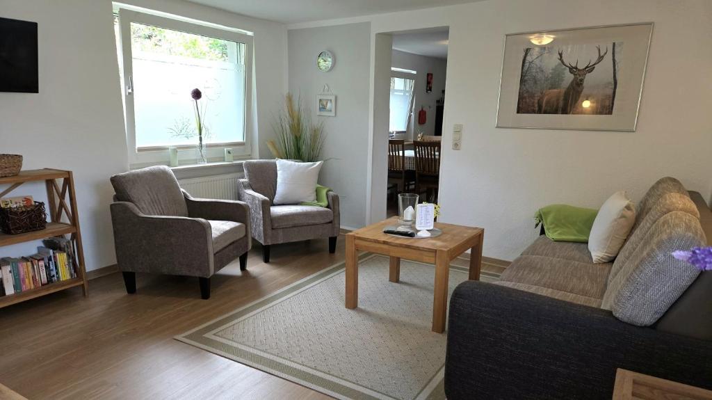 a living room with a couch and two chairs and a table at FeWo Rothirsch - Heuser Prerow in Prerow