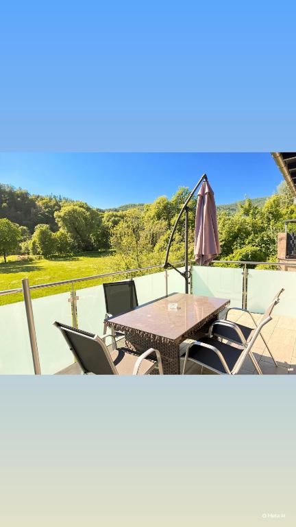 a table with chairs and an umbrella on a patio at Komfortresidenz Harmonie in Weiz