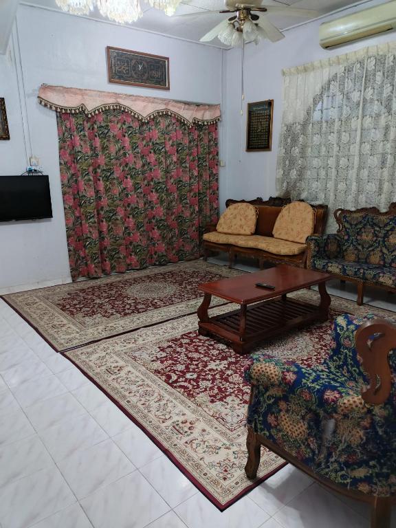 a living room with a couch and a table at Homestay Rumah Inap ABC Semi-D in Pasir Mas