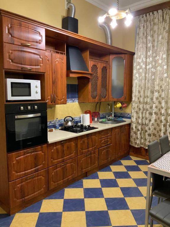 a kitchen with wooden cabinets and a stove top oven at Український Театр 2-х кімнатні Апартаменти in Odesa