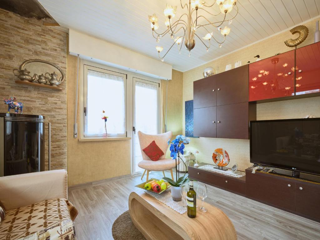 a large living room with a couch and a television at Casa Heli 1 lake view in San Zeno di Montagna