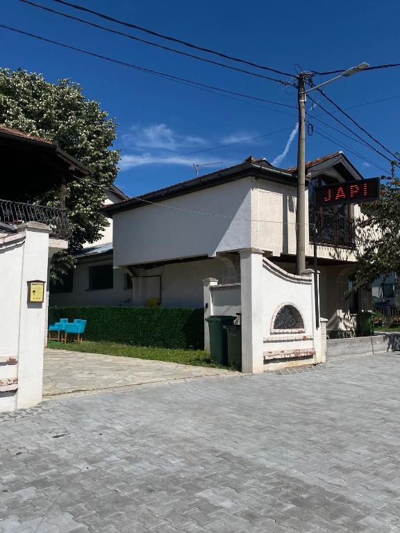 a white building with a fireplace in front of it at Hostel JAPI in Aleksinac