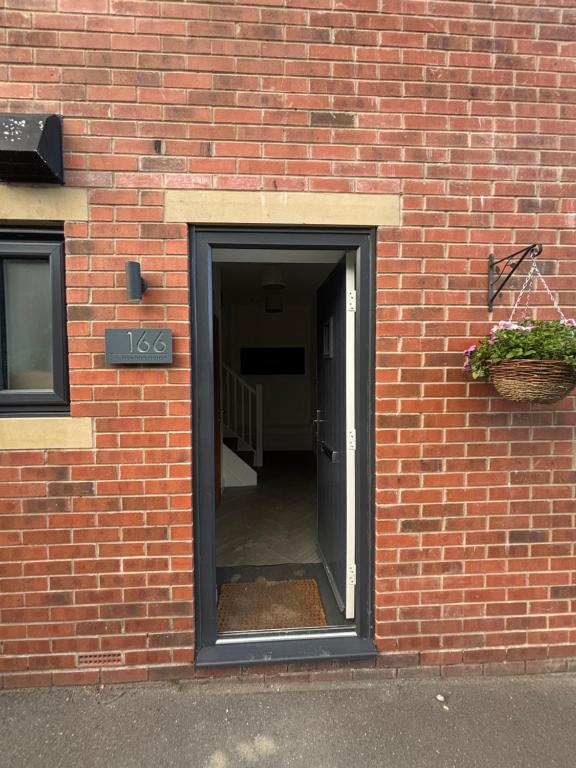 a brick building with an open door with a basket at Nirvana house in Deepcar