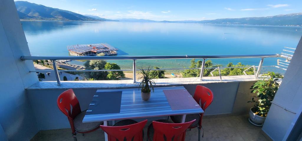 a balcony with a table and chairs and a view of a lake at Aldo's apartments in Pogradec
