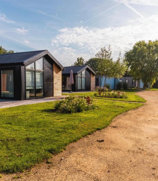 a house with a black roof and a grass yard at Velthorst 6 in Warmond