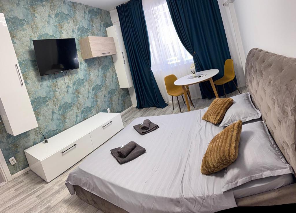 a bedroom with a bed with two slippers on it at Happy Studio 1 in Craiova