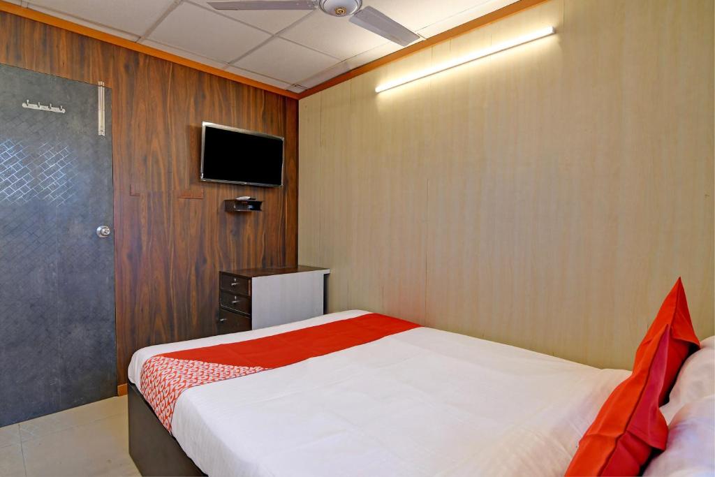 a small bedroom with a bed and a tv at Hotel O Jalan Regency in Kolkata