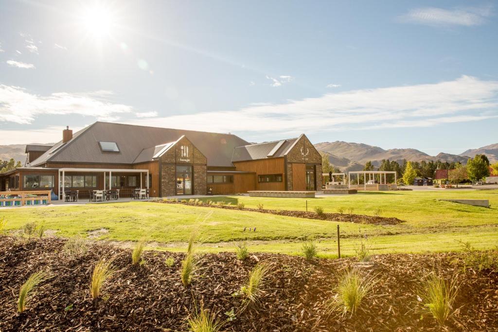 a large house with a grass field in front of it at The Harvest Hotel in Cromwell