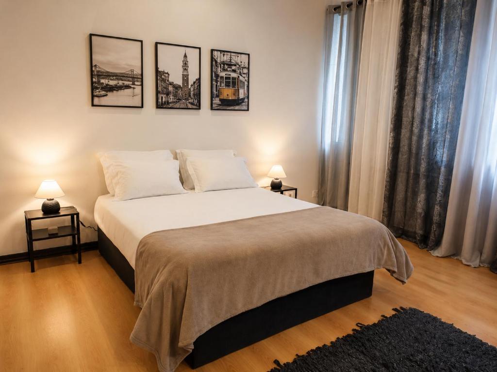 a bedroom with a large bed with three pictures on the wall at Espaço-Zero Downtown Porto in Porto