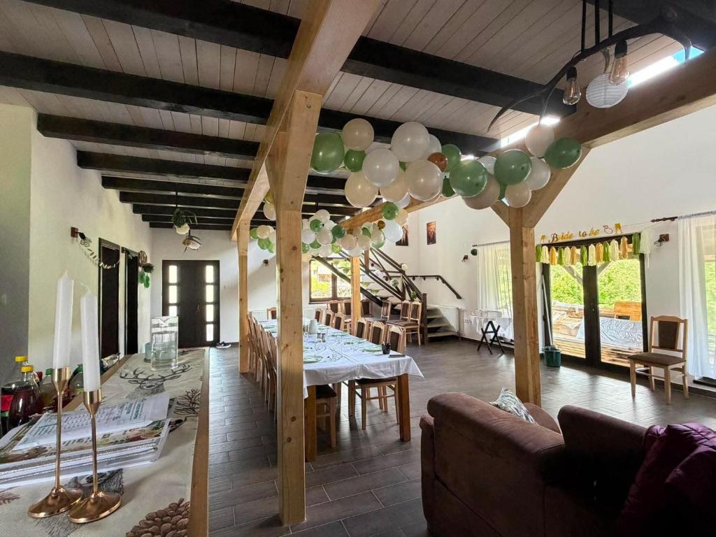 a dining room with a table and balloons on the ceiling at Csodaszarvas Erdeiház in Borzont