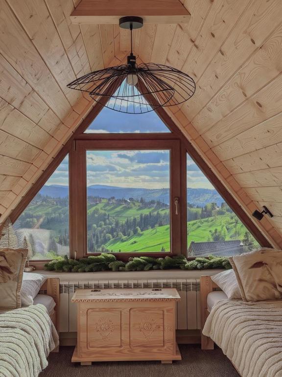 a large window in a room with two beds at Domki Widokowelove z widokiem na panoramę Tatr - mountain view in Gliczarów