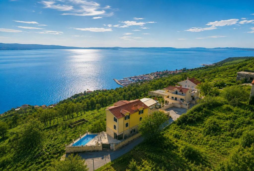 an aerial view of a house on a hill next to the water at Villas Verde Dalmatia in Jesenice