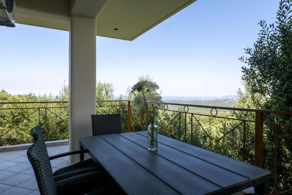 a wooden table on a balcony with a view at Anima Horizon - Terra apartment in Elaiófiton