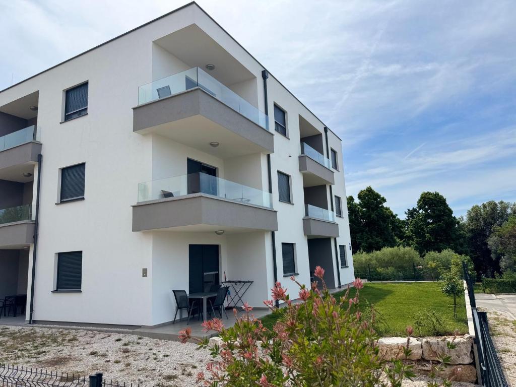 a white apartment building with a balcony at Apartments Frank in Zambratija