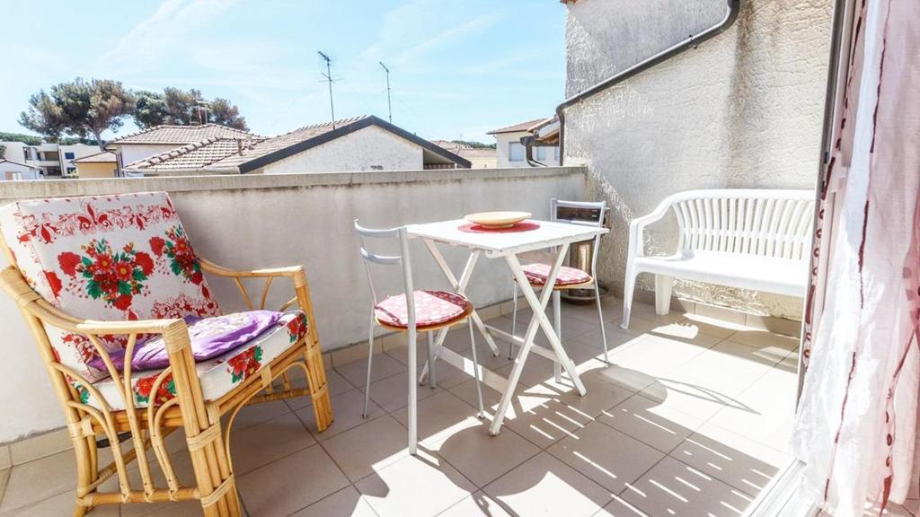 a small balcony with a table and chairs on a roof at Casa Guia a Marina di Cecina con parcheggio privato in Marina di Cecina