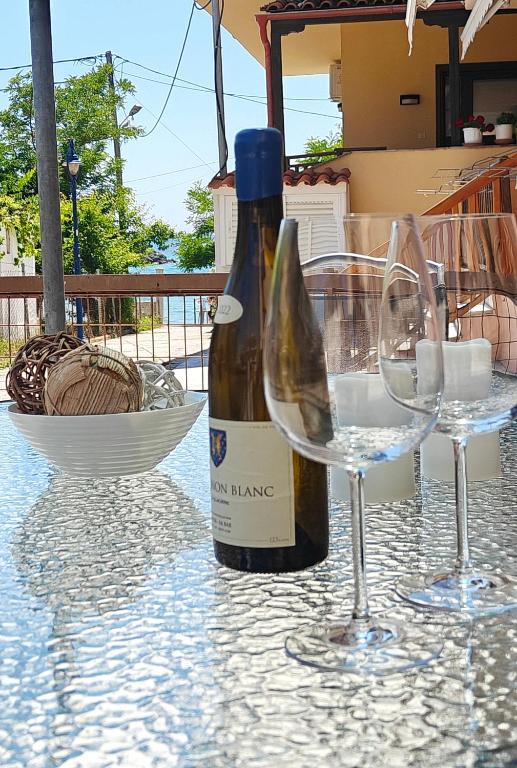 a bottle of wine and two glasses on a table at Barefoot Nest in Nea Skioni