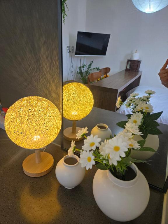 two lamps and vases with flowers on a table at 여유스테이 2호점 in Suwon