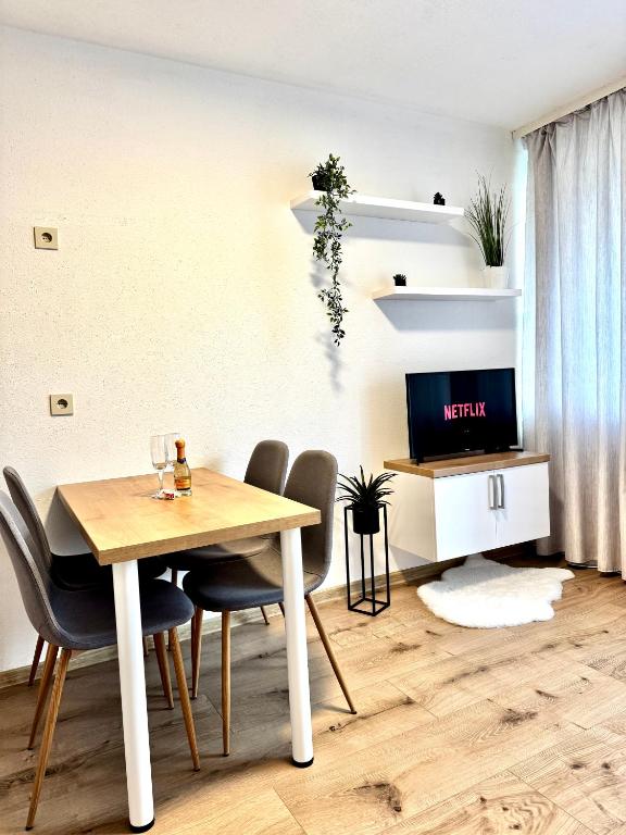 a dining room with a table and chairs and a tv at Adriany apartmán in Bayerisch Eisenstein