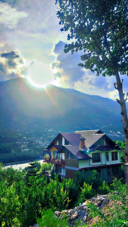 a house on top of a hill with a rainbow at Falak Stays in Shamshi